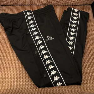 Kappa trackpants - Kappa trackpants med knäppning längst sidorna, skulle säga att de sitter mer som en M i ”herr” storlek. Nästan som nya då de är knappt använda.