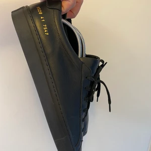 Common projects 7 (41) - Common projects stora i strlk, passar 42. Svarta bra skick 1500kr, vita använt skick 1000kr, beiga gott skick 1250.