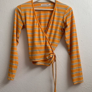 Randig topp - Säljer min topp från junkyard. Den har ett skönt och tunt material. Man knyter den på sidan vilket ger en avsmalning i midjan. 