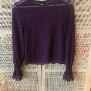 Tunn lila topp  - Tunn topp från Bikbok. Tyget är i tyll och man ser igenom det. Toppen har klockärmar vilket kan vara skitsnyggt att låta sticka fram under en tröja. Storlek 34.