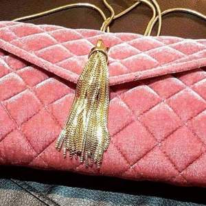 Axelremsväska i rosa sammet med guldstrass och guldkedja. Använd 1 gång. 