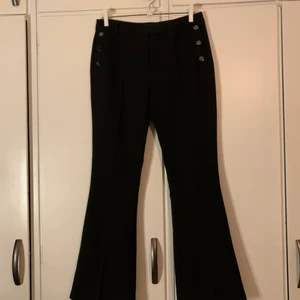 kostym byxor  - ett par lågmidjade svarta kostym byxor med silver knapar på fickorna i st 38