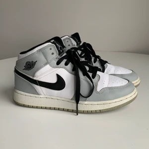 Air Jordan 1 - Äkta Air Jordan 1 mid i light smoke grey, köpta på StockX(kvitto finns). Använt men fint skick! Två sömmar på den vänstra plösen har dessvärre gått upp, men det syns ej när skorna är knytna. Skickas i originalkartong. Fraktkostnad tillkommer. (Lägger upp igen pga oseriös köpare.)