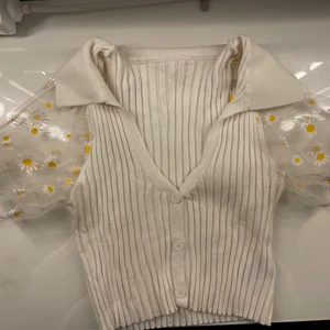 Ribbad top med blommor - Jötte jätte fin ribbad t-shirt med prästkragar på armarna, tyvärr är den förliten annars hade jag använt den 24/7, den är i ett väldigt stretchiga material o skulle säga att den passar xs/s ungefär 