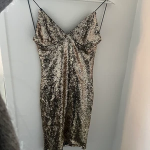 Guldglittrig klänning Rebecca Stella - Säljer denna guldglittriga klänning från Rebecca Stella!! Helt oanvänd med lapp kvar. XS men väldigt stretchig i både band och tyg, så möjlig S. Fin till nyår✨ möts i Sthlm.