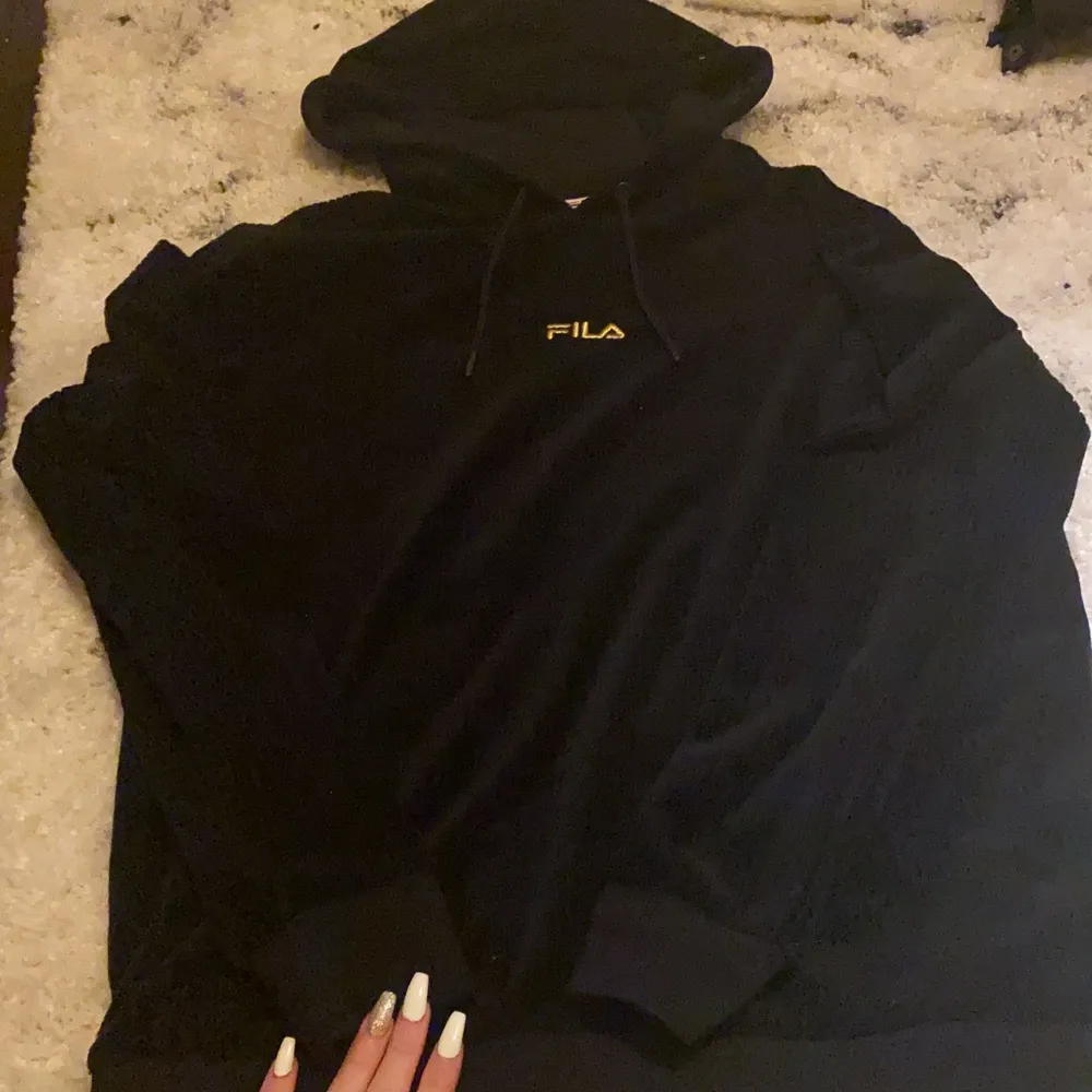 En svart Fila hoodie storlek M skit skönt material de är mjukt, använt få gånger helt ren. Fila märket där fram med guldig text säljer för 250 ink frakt☺️❤️. Hoodies.