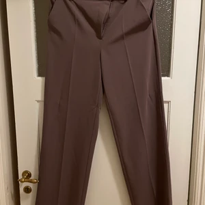 Kostymbyxor med wide leg fit - Kostymbyxor med en wide leg fit. En mörk brun/ lila ish färg, super fin färg och super bekväma. Köpta från NA-KD.
