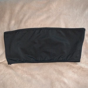 Svart bandeau-topp - Svart bandeau-topp i mjukt och lite glansigt material, helt oanvänd. Frakt tillkommer, skriv vid intresse:)