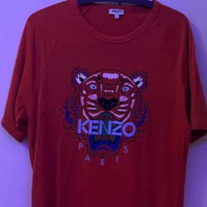 Kenzo Äkta Röd T-Shirt i Medium - Äkta Kenzo T-shirt som jag köpte från Merchsweden i vintras. Jag har använt den en gång och den är i jättebra skick. Jag är 170 och den sitter bra på mig men den är lite baggy ifall ni undrar om några mått kan ni skriva. Ifall ni har några frågor är det bara att skriva. Kan göra meetup i sthlm.
