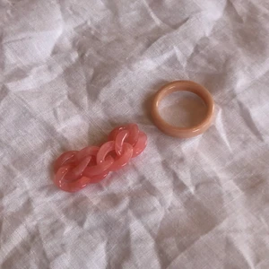 Rosa ringar - Två rosa ringar av plast. Ringarna är ganska små men man kan ha dom på lillfingret o ringfingret (som på bild två) då passar dom förmodligen dom flästa 💗 aldrig använda. Kedjeringen - 50 kr. Ring - 10. Allt för 50 KEDJERING SOLD❌