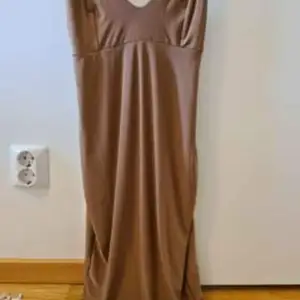 Figursydd klänning från Rebecca Stella i brun nude färg strl M som även passar S. Klänningen är använd vid ett tillfälle.