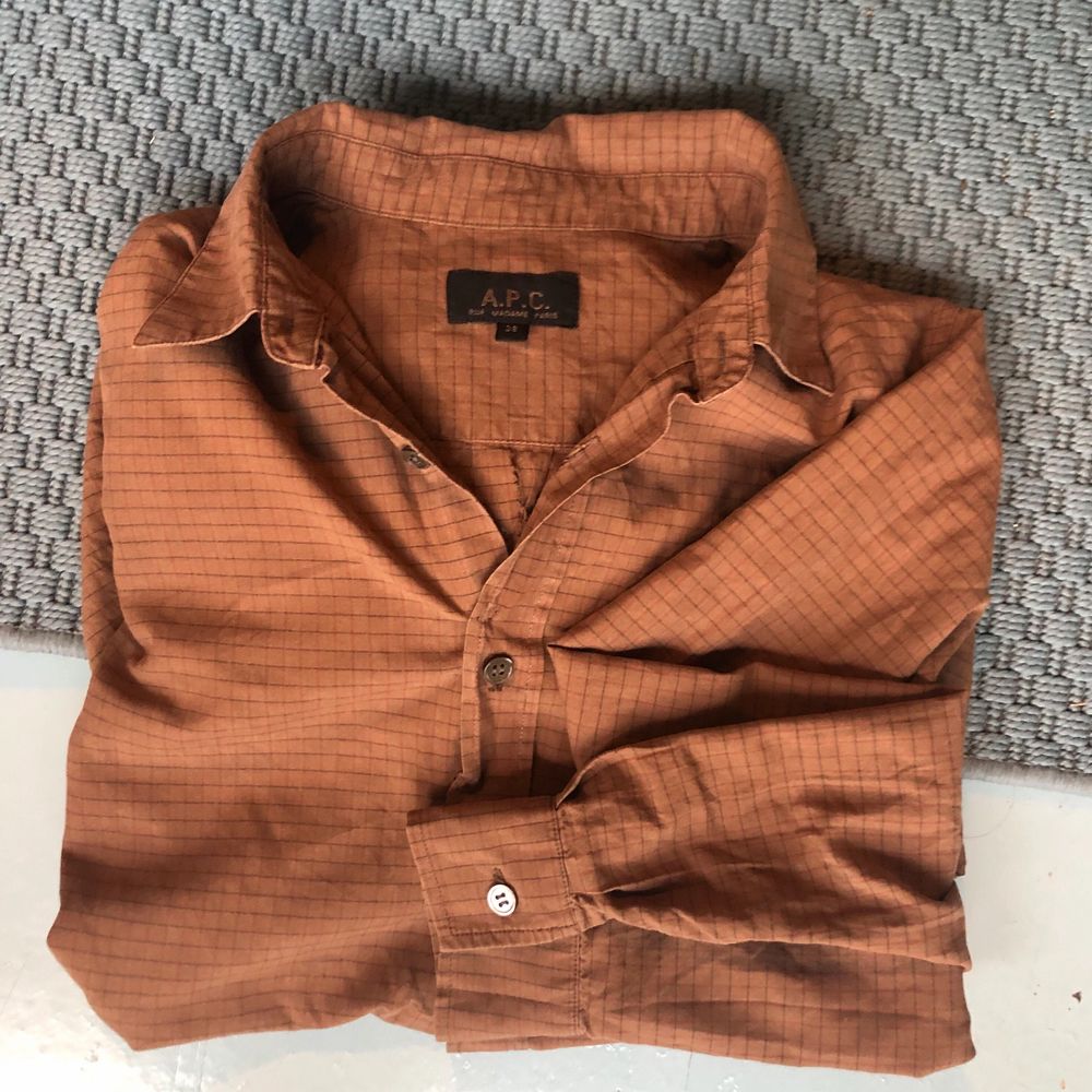 En brun skjorta med ett svagt rutmönster. Tunnare material.. Skjortor.
