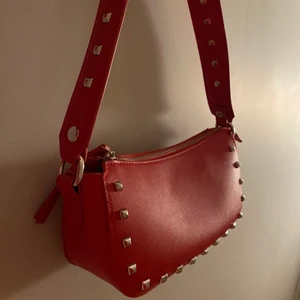 Röd handväska  - En väldigt snygg rödhandväska, stor inuti. Tillkommer med en silver kedja att ha så man kan ha den som axelväska. Nypris 300kr mitt pris 150kr. Köparen står för frakt