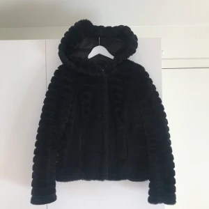 VILA pälsjacka strl 36 - Gullig svart fuskpälsjacka som har en stor supermysig luva. Jackan är använd men har inga skador. Nypris 900kr. Köparen står för frakt 🚚 