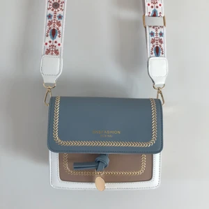 Liten blå och beige väska - Supersöt liten väska som passar till allt. Den letar ett nytt hem då den tyvärr aldrig kommit till användning här :(