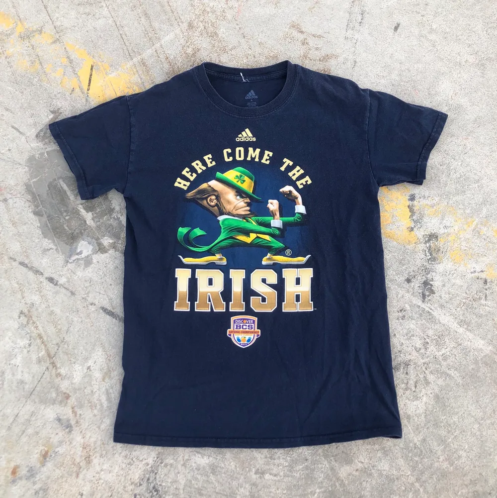 Sjukt snygg college t-shirt producerad av Adidas åt Notre dame, Indiana och deras Amerikanska fotbollslag Fighting Irish från National Championship 2013. Tröjan är S men passar något mindre. Sjukt snyggt tryck. Tröjan är även i grymt skick och inga direkta defekter. Tveka inte att höra av dig om du undrar något! 🌱✌🏻🏈. T-shirts.