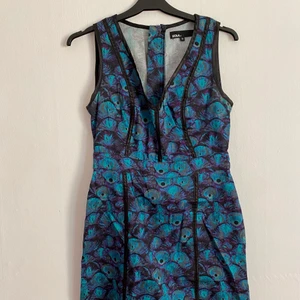 Fodralklänning med påfågel-mönster - Fin fodralklänning i fint skick. Mycket sparsamt använd. 