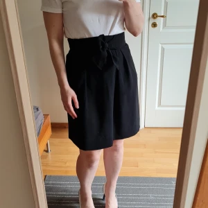 Black short skirt - Black short skirt with zipper and button fastening from H&M. Classic looks makes it great for every occasion. Flowy fabric, cute bow in front 🥰 Used only once. Waist 36 cm, total length 54 cm.