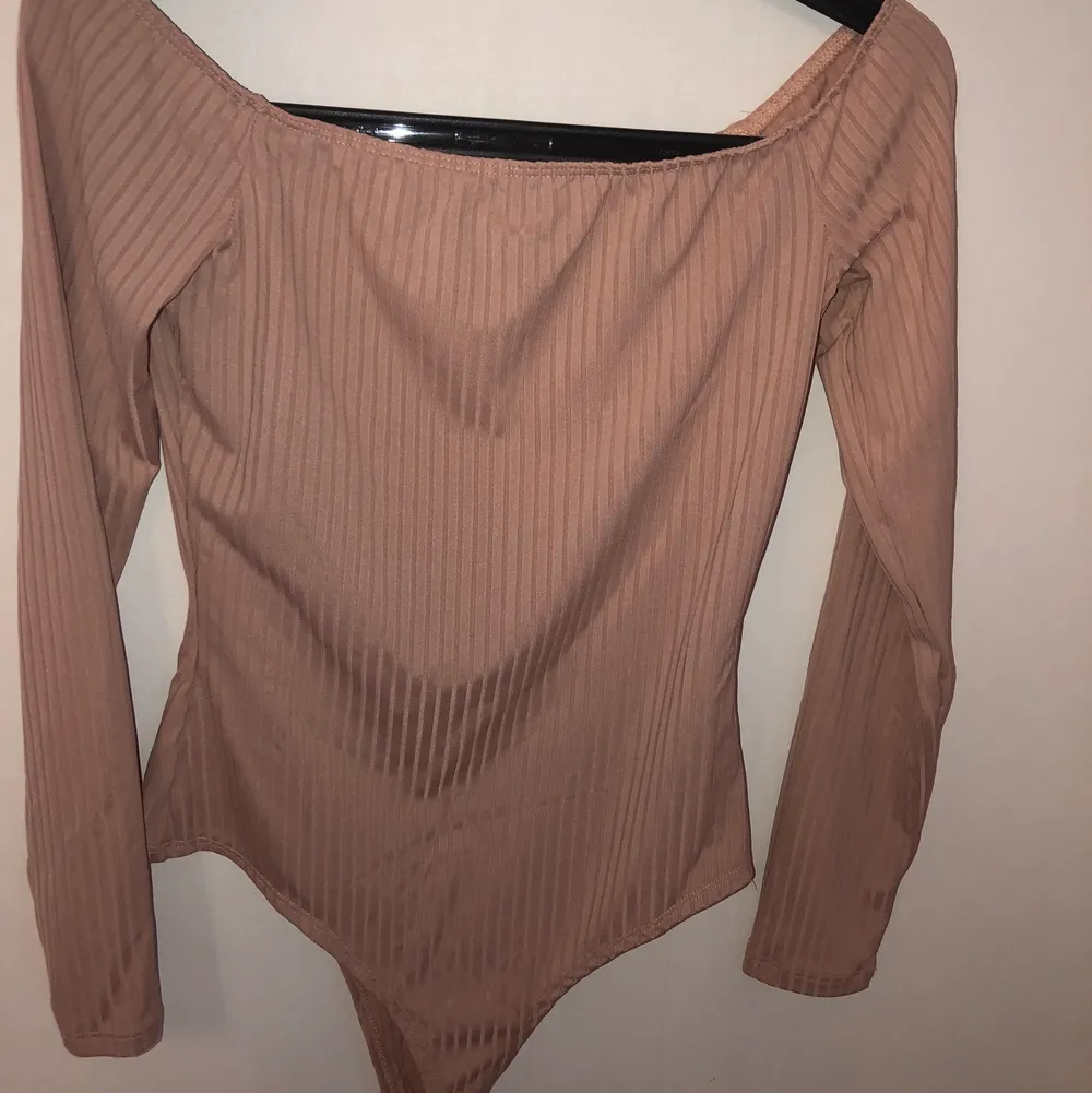 Beige, ribbad off shoulder body från Nelly, storlek S. Du stänger bodyn med knappar! Använd en gång🤍 . Toppar.