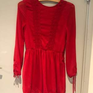 Superfin röd klänning från HM med spetsdetaljer och knytning i ryggen. Använd två gånger. 