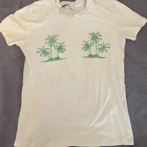 Stl S vit t-shorts med gröna palmer på. Sparsamt använd i god kvalitet. 