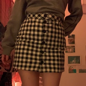 Rutig kjol - Svart/vit rutig kjol med knappar köpt ca två år sedan på H&M. Knappt använd!