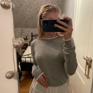 Grå Finstickad Tröja - Ljusgrå finstickad tröja med vita detaljer vid ärmar och krage, väldigt mysig nu till hösten🤍🍁 Säljer då den inte kommer till användning men den är i fint skick! Köparen står för frakt, skriv privat vid frågor🤍🤍🤍