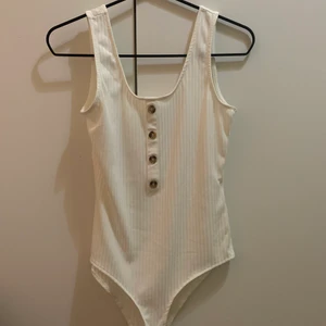 Body - En vit body med knappar köpt från Hm, aldrig använd 🤍