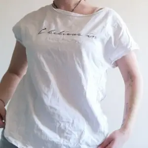 En enkel vit t-shirt som är lite nära off The shoulder. Om man undrar så säger texten 