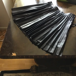 Svart lila leather kjol. - I mycket bra skick och passar 30- 32.Finns fler bilder och bud i kommentarna eller köp direkt för 350