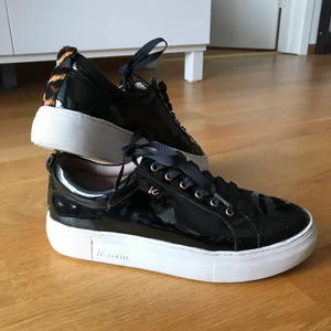 Lackskor K. Cobler - Snygga lackskor från K.Cobler i fint skick med leoparddetaljer. Använda ett fåtal gånger. Pris kan diskuteras. Säljs pga att de inte kommer till användning. Köparen står för frakt. Nypris 999 kr