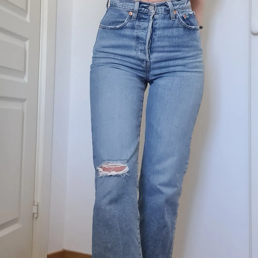 Levi's jeans i modell ribcage straight ankel, med hål på vänstra knä. Storlek 24. Köparen står för frakt🥰. Jeans & Byxor.