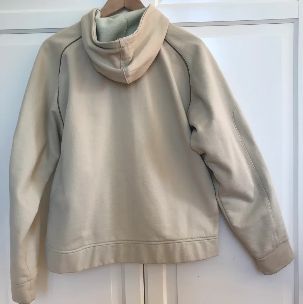 En beige hoodie som är lite oversized med fina detaljer på ärmarna. Det står storlek L men passar mer som en stor M.. Tröjor & Koftor.