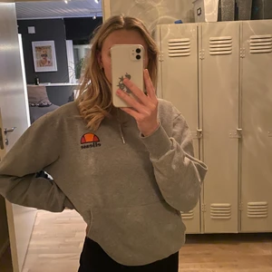 Ellesse hoodie - Snygg hoodie från ellesse! Fint skick, förutom 2 pyttepyttesmå fläckar på magen (som troligtvis går bort i tvätten) & slitning vid armmudden! Se bild nr 2! Köparen står för fraktkostnaden 🤗