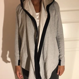 Grå adidas kofta med luva storlek XS - Grå adidas kofta med luva och dragkedjor på sidorna. Snyggt med ett linne under eller när du ska gå träna. Även över jeans är den fin. Storlek XS