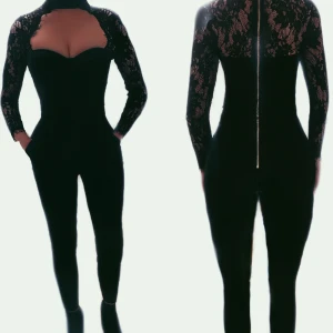 Jumpsuit dressad - Den absolut finaste jumpsuit som jag någonsin ägt. Den sitter superfint på alla kroppar. (Den ser lite tråkig ut hängandes på galge. Nederdelen är en konstymbyxa med lite elasticitet (raka, följer benet, inte slappa eller utsvängda nedtill). Ovandelen är delvis: armar rygg detaljer spets. Samt framsidan är ursnyggt formad som en stadig kosett med lite elasticitet. Samt ett band runt halsen. På baksidan är det dragkedja hela vägen upp till nacken. Aldrig använd men provad ett par ggr i hopp om att den ska passa. Fantastiskt välsytt plagg som ger mycket för pengarna! 