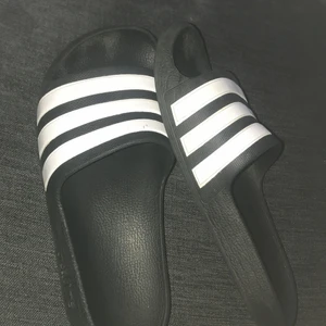 Adidas tofflor - Använda men säljer pga av att de ej passar så bra längre, är i gott skick! Dem är så bekväma att bara sätta på sig när man ska iväg till stranden eller när man bara vill sätta på sig nått enkelt. Är inte helt säker på storlek då de ej står på dem men tror det är 35/36 :)
