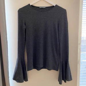 Topp - En grå långärmad topp.