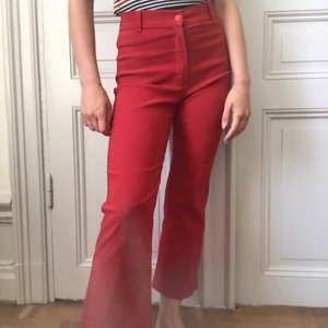 Röda utsvängda byxor - Hög midja, knapp och dragkedja fram, kortare utsvängda ben. Bra skick!