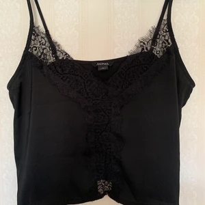 Top från Monki - Använd 1 gång. Supersöt topp från monki med spets på framsidan och små slits på sidan. Har justerbara band. Storlek S