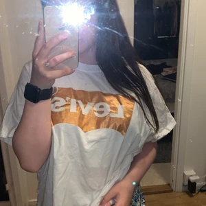 Levis  - En vit tröja men mörkret Levis på och det är guld färgat