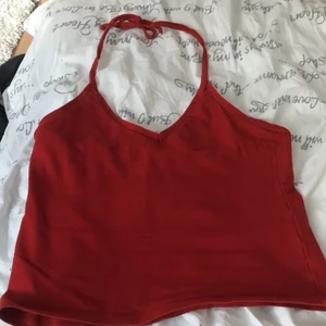 Röd topp - Säljer denna fina röda topp. Den går att ha på olika sätt och är stretchig, skulle säga att det passar S-M. Lappen där det står storlek och vart den är ifrån är borta.