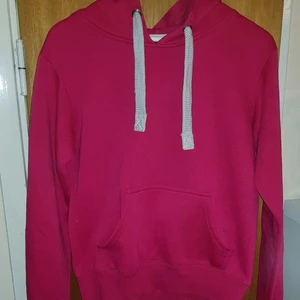 Rosa hoodie i storlek L - Hoddie i en mörkrosa färg i storlek L. Bra skick då den endast är använd fåtal gånger. Används inte för att jag bytt stil. Sitter som en vanlig hoodie.