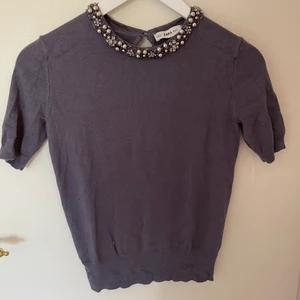 T-shirt  - En T-shirt med detalj med stenar i grått 