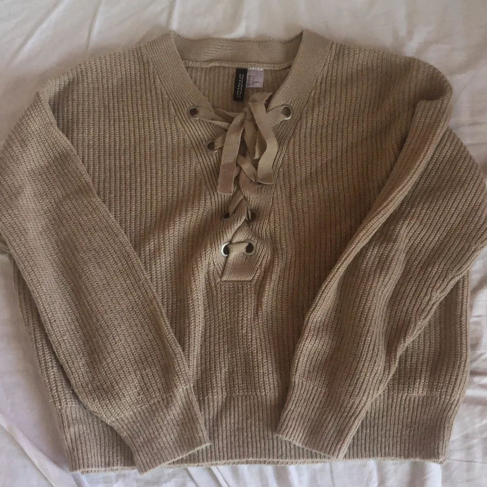 En beige stickad tröja med knytning vid bysten🌸 säljer då den inte används längre, kom gärna med förslag på priser! . Stickat.