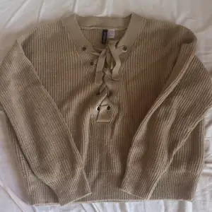 En beige stickad tröja med knytning vid bysten🌸 säljer då den inte används längre, kom gärna med förslag på priser! 
