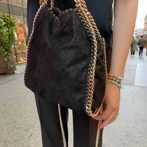 Stella McCartney väska - Svart Stella McCartney väska med guldkedjor i modellen Falabella mini tote. ‼️Säljer ej‼️ är endast intresserad av att byta till en annan färg eller modell. Jag har tyvärr inget kvitto men dustbag medföljer! 💞 Man ser även på väskan att den är äkta ☺️ Det är också folk som tror att de kan försöka få mig att sälja väskan för en tusenlapp, jag säljer inte ‼️‼️