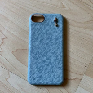Skal till iPhone 6/6s - Ett ljusblått mobil skal till iphone 6 och 6s. Har en fin diamant som detalj och runt kameran är det roséguld.