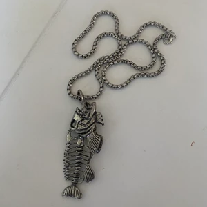 Fisk halsband - Ett coolt halsband med en skelett fisk som motiv. Kommer ej till användning därav säljes. I fint skick!