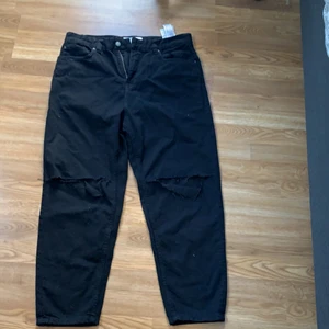 Berskha jeans - Säljer ett par feta svarta håliga mom jeans från bershka. Dessa är i storleken 42 och är extremt sköna! Dessa säljs pågrund av fel storlek. 